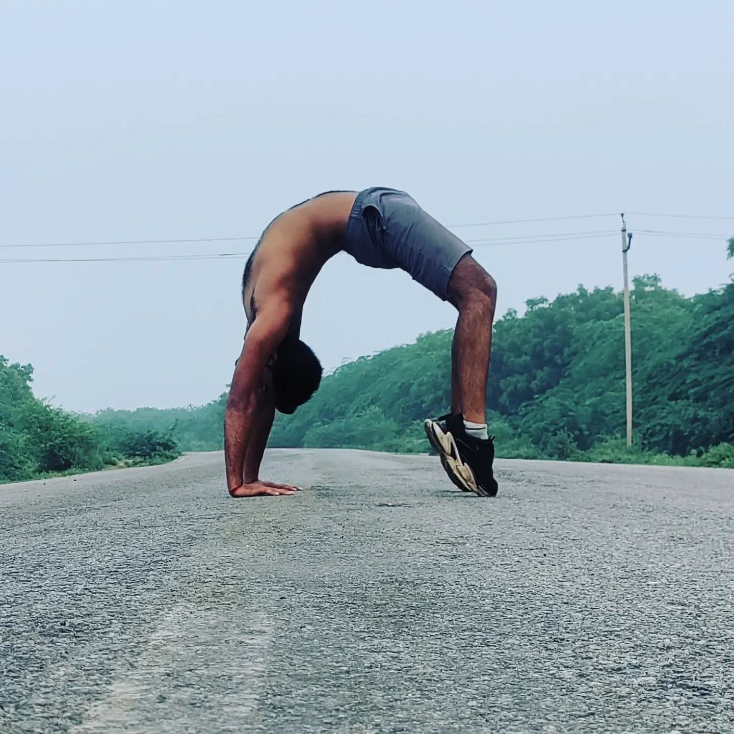 Aditya Pratap Singh in a wheel pose on an open road